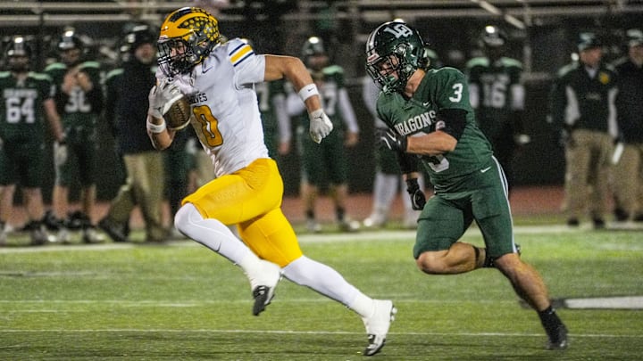 Clarkston RB Griffin Boman runs for a touchdown with Lake Orion's William Hoffman on his tail Friday, Nov. 1, 2024.