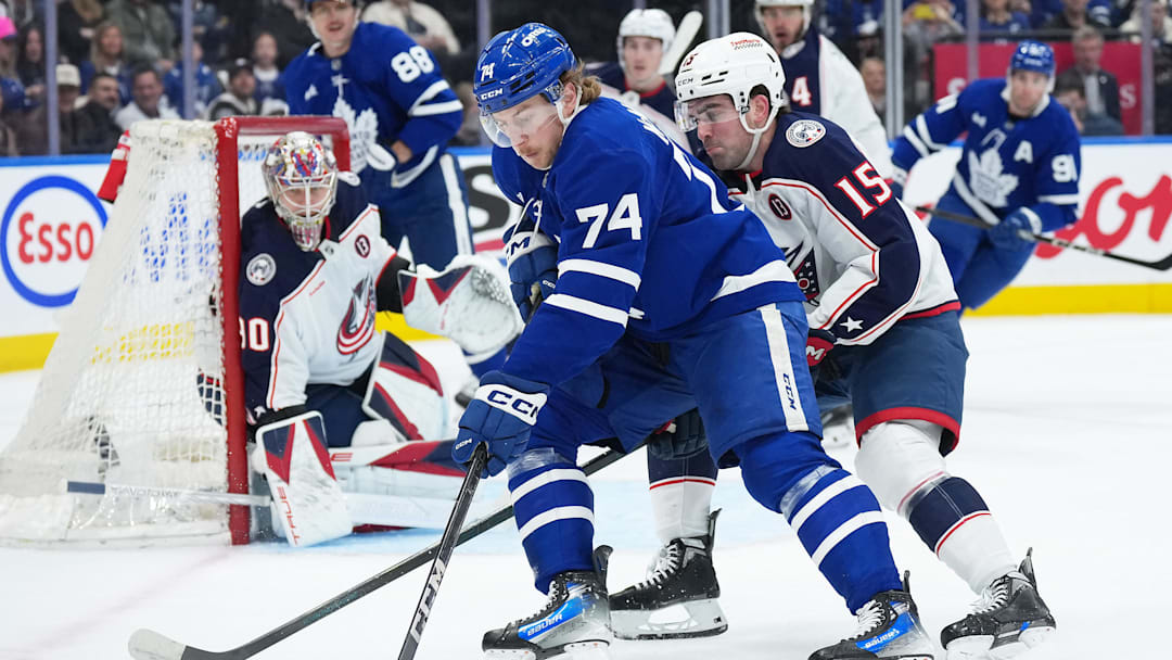 Apr 5, 2025; Toronto, Ontario, CAN; Toronto Maple Leafs center Bobby McMann (74) battles for the puck with Columbus Blue Jackets defenseman Dante Fabbro (15) during the first period at Scotiabank Arena. Mandatory Credit: Nick Turchiaro-Imagn Images