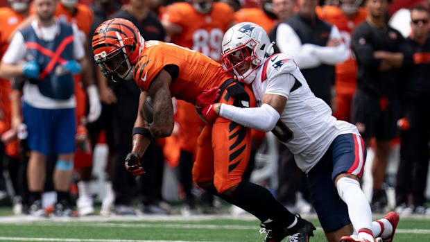 Cincinnati Bengals wide receiver Ja'Marr Chase (1) is tackled by New England Patriots corner back Christian Gonzalez (0) in t