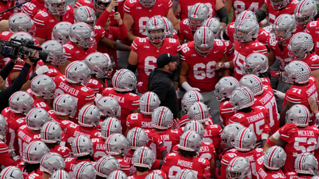 Coach surrounded by team before game.