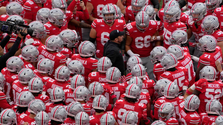 Ohio State coach Ryan Day huddles with his players before a game.