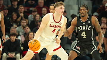 Jan 29, 2025; Starkville, Mississippi, USA; Alabama Crimson Tide forward Grant Nelson (4) looks to pass the ball against Mississippi State Bulldogs forward Cameron Matthews (4) during the second half at Humphrey Coliseum. Mandatory Credit: Wesley Hale-Imagn Images