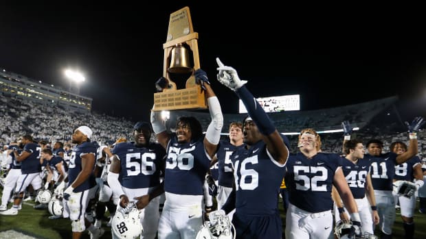 Penn State Nittany Lion players celebrate with the Governor's Victory Bell trophy.