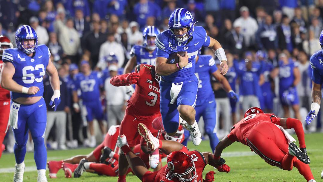 Oct 18, 2025; Provo, Utah, USA; BYU Cougars quarterback Bear Bachmeier (47) runs for a touchdown against Utah Utes defensive tackle Pupu Sepulona (45), cornerback Elijah Davis (9) and linebacker Levani Damuni (3) during the second half at LaVell Edwards Stadium. Mandatory Credit: Rob Gray-Imagn Images