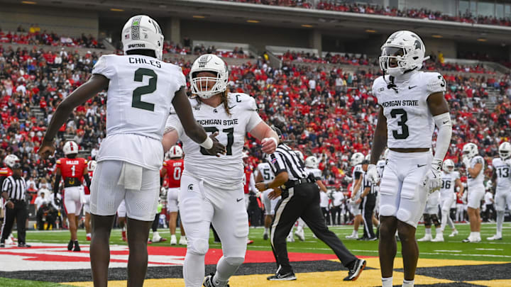 Sep 7, 2024; College Park, Maryland, USA; Michigan State Spartans quarterback Aidan Chiles (2) celebrates with teammates in the enzyme after throwing a first quarter touchdown against the Maryland Terrapins  at SECU Stadium. Mandatory Credit: Tommy Gilligan-Imagn Images