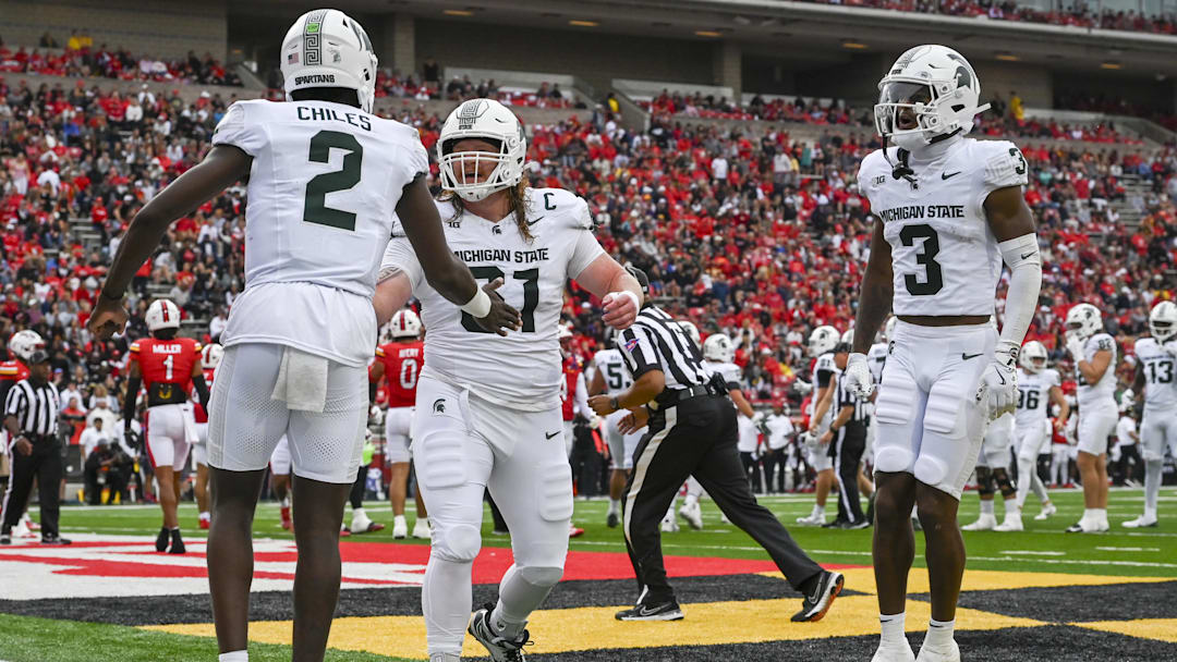 Sep 7, 2024; College Park, Maryland, USA; Michigan State Spartans quarterback Aidan Chiles (2) celebrates with teammates in the enzyme after throwing a first quarter touchdown against the Maryland Terrapins  at SECU Stadium. Mandatory Credit: Tommy Gilligan-Imagn Images