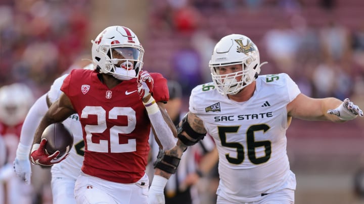 Sep 16, 2023; Stanford, California, USA; Stanford Cardinal running back E.J. Smith (22) runs with the ball past Sacramento State Hornets defensive lineman Brandon Knott (56) during the second quarter at Stanford Stadium. Mandatory Credit: Sergio Estrada-USA TODAY Sports