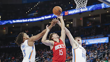 Oct 9, 2024; Oklahoma City, Oklahoma, USA; Houston Rockets guard Reed Sheppard (15) reaches for a rebound between Oklahoma City Thunder forward Dillon Jones (3) and guard Alex Ducas (88) during the second half at Paycom Center. Mandatory Credit: Alonzo Adams-Imagn Images