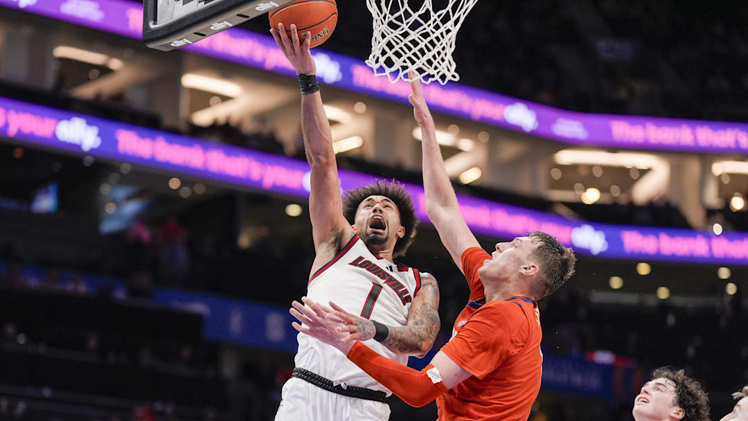 Mar 14, 2025; Charlotte, NC, USA; Louisville Cardinals guard J'Vonne Hadley (1) goes to the basket against Clemson Tigers center Viktor Lakhin (0) during the second half at Spectrum Center. Mandatory Credit: Jim Dedmon-Imagn Images