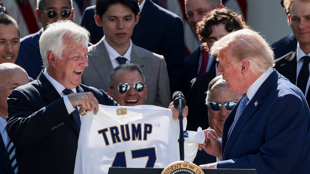 Mark Walter, CEO of Guggenheim Partners, presents U.S. President Donald Trump with a jersey with Trump's surname and a number "47", during a reception for the reigning Major League Baseball (MLB) World Series champion Los Angeles Dodgers in the Rose Garden at the White House, Washington, D.C., U.S., July 23, 2026.
