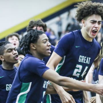 Great Crossing's Malachi Moreno (24) and teammates mob Vince Dawson (1) in jubilation after Dawson's last second shot lifted the Warhawks 48-46 over Newport at Thursday's 2023 Chad Gardner Law King of the Bluegrass holiday basketball tournament at Fairdale High School. Dec. 21, 2023