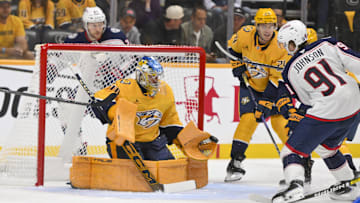 Oct 9, 2025; Nashville, Tennessee, USA; Nashville Predators goaltender Juuse Saros (74) blocks the shot of Columbus Blue Jackets center Kent Johnson (91) during the first period at Bridgestone Arena. Mandatory Credit: Steve Roberts-Imagn Images