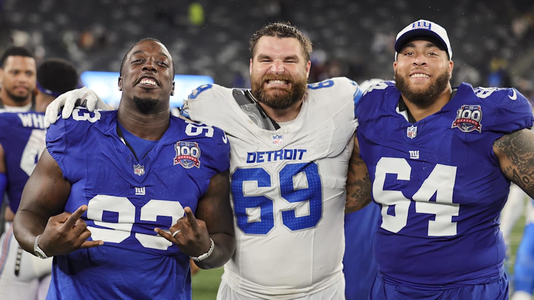 Aug 8, 2024; East Rutherford, New Jersey, USA;  New York Giants defensive tackle Rakeem Nunez-Roches (93), Detroit Lions defensive end Pat O'Connor (69) and New York Giants guard Aaron Stinnie (64) pose for a group photo after their preseason game at MetLife Stadium. Mandatory Credit: Scott Rausenberger-Imagn Images