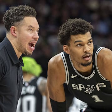 San Antonio Spurs interim head coach Mitch Johnson talks with center Victor Wembanyama during a free throw against the Minnesota Timberwolves in the second half at Target Center.