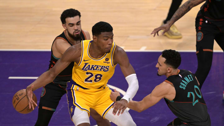 Feb 29, 2024; Los Angeles, California, USA;  Los Angeles Lakers forward Rui Hachimura (28) loses control of the ball as he is defended by Washington Wizards guard Tyus Jones (5) and guard Landry Shamet (20) in the first half at Crypto.com Arena. Mandatory Credit: Jayne Kamin-Oncea-USA TODAY Sports
