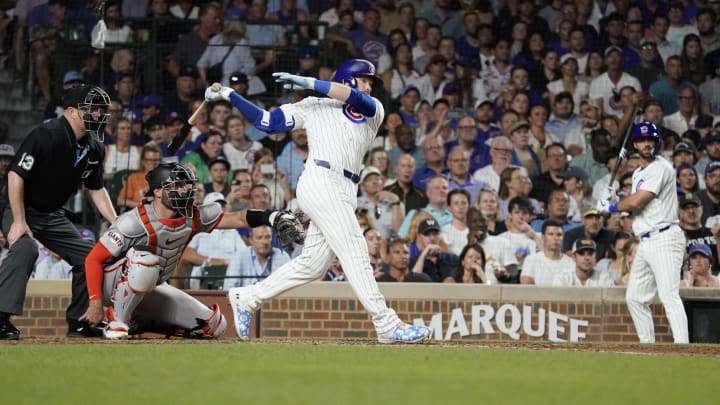 Jun 18, 2024; Chicago, Illinois, USA; Chicago Cubs outfielder Ian Happ (8) hits a one run single against the San Francisco Giants during the eighth inning at Wrigley Field.