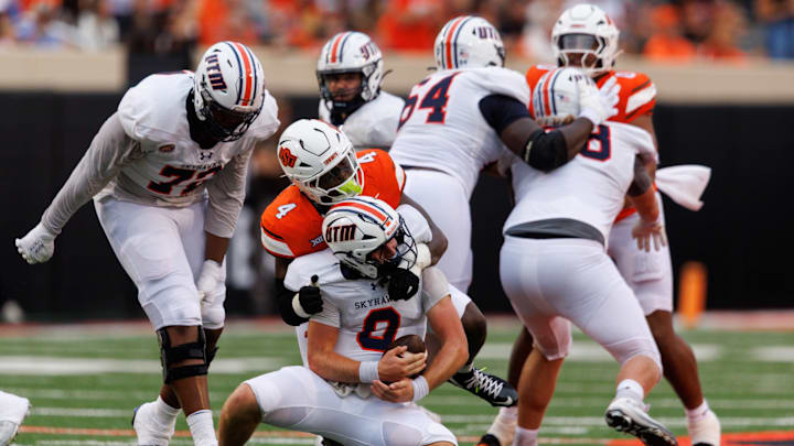 Aug 28, 2025; Stillwater, Oklahoma, USA; Tennessee Martin Skyhawks quarterback Jase Bauer (8) is sacked by Oklahoma State Cowboys linebacker Wendell Gregory (4) during the first half  at Boone Pickens Stadium. Mandatory Credit: William Purnell-Imagn Images