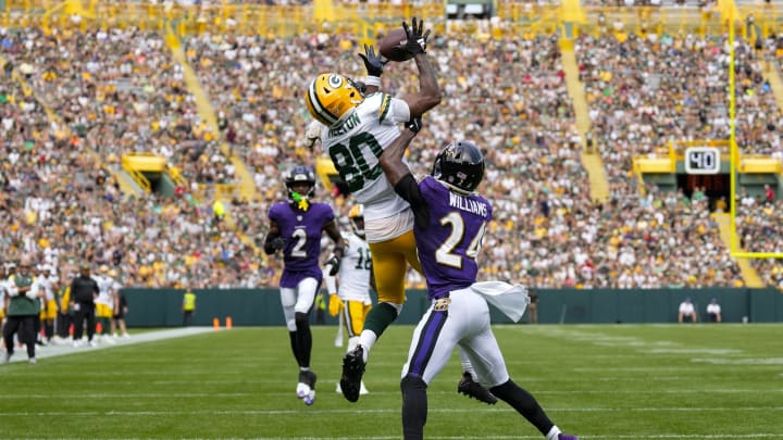 Green Bay Packers wide receiver Bo Melton (80) leaps to catch a touchdown pass as Baltimore Ravens cornerback Damarion Williams (24) defends on Saturday.