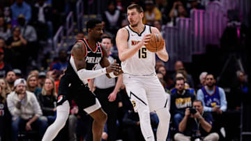 Feb 10, 2025; Denver, Colorado, USA; Denver Nuggets center Nikola Jokic (15) controls the ball as Portland Trail Blazers center Deandre Ayton (2) guards in the first quarter at Ball Arena. Mandatory Credit: Isaiah J. Downing-Imagn Images
