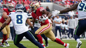 Nov 17, 2024; Santa Clara, California, USA; San Francisco 49ers running back Jordan Mason (24) rushes the ball whlie being pursued by Seattle Seahawks cornerback Coby Bryant (8) in the first quarter at Levi's Stadium. Mandatory Credit: David Gonzales-Imagn Images