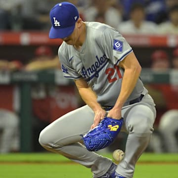 Sep 3, 2024; Anaheim, California, USA;  Los Angeles Dodgers starting pitcher Walker Buehler (21) is able to control the ball and throw Los Angeles Angels first baseman Nolan Schanuel (18) out at first in the fifth inning at Angel Stadium. Mandatory Credit: Jayne Kamin-Oncea-Imagn Images