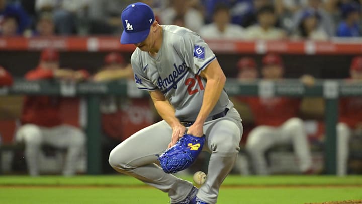 Sep 3, 2024; Anaheim, California, USA;  Los Angeles Dodgers starting pitcher Walker Buehler (21) is able to control the ball and throw Los Angeles Angels first baseman Nolan Schanuel (18) out at first in the fifth inning at Angel Stadium. Mandatory Credit: Jayne Kamin-Oncea-Imagn Images