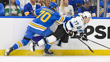 Oct 23, 2025; St. Louis, Missouri, USA; St. Louis Blues center Oskar Sundqvist (70) checks Utah Mammoth right wing JJ Peterka (77) during the first period at Enterprise Center. Mandatory Credit: Jeff Curry-Imagn Images