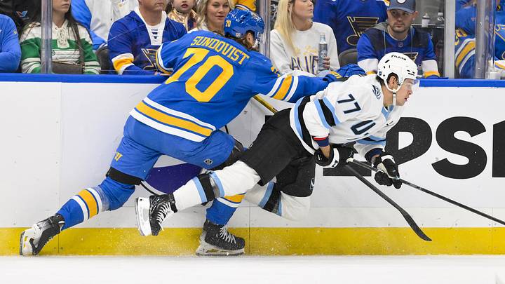Oct 23, 2025; St. Louis, Missouri, USA; St. Louis Blues center Oskar Sundqvist (70) checks Utah Mammoth right wing JJ Peterka (77) during the first period at Enterprise Center. Mandatory Credit: Jeff Curry-Imagn Images