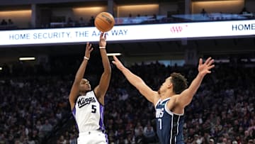Dec 30, 2024; Sacramento, California, USA; Sacramento Kings guard De'Aaron Fox (5) shoots against Dallas Mavericks center Dwight Powell (7) during the third quarter at Golden 1 Center. Mandatory Credit: Darren Yamashita-Imagn Images
