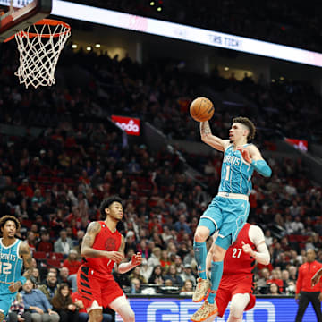Dec 26, 2022; Portland, Oregon, USA; Charlotte Hornets point guard LaMelo Ball (1) drives to the basket past Portland Trail Blazers shooting guard Anfernee Simons (1), Jusuf Nurkic (27), and Jerami Grant (9) during the second half at Moda Center. Mandatory Credit: Soobum Im-Imagn Images