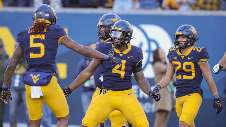 West Virginia Mountaineers running back CJ Donaldson Jr. (4) celebrates with teammates after running for a touchdown against the Cincinnati Bearcats during the second quarter at Mountaineer Field at Milan Puskar Stadium. 