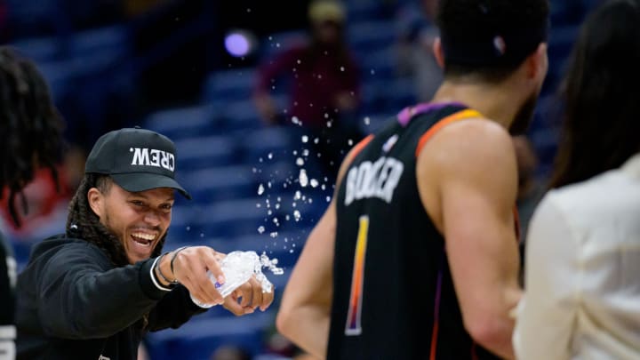 Apr 1, 2024; New Orleans, Louisiana, USA; Phoenix Suns guard Damion Lee, left, sprays his teammate Phoenix Suns guard Devin Booker (1) with water after the Suns defeated the New Orleans Pelicans at Smoothie King Center. Mandatory Credit: Matthew Hinton-USA TODAY Sports