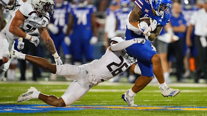 Sep 1, 2023; Lawrence, Kansas, USA; Kansas Jayhawks running back Dylan McDuffie (25) is tackled by Missouri State Bears linebacker Tahj Chambers (26) during the second half at David Booth Kansas Memorial Stadium. Mandatory Credit: Jay Biggerstaff-Imagn Images Sep 1, 2023; Lawrence, Kansas, USA; Kansas Jayhawks running back Dylan McDuffie (25) is tackled by Missouri State Bears linebacker Tahj Chambers (26) during the second half at David Booth Kansas Memorial Stadium. Mandatory Credit: Jay Biggerstaff-Imagn Images