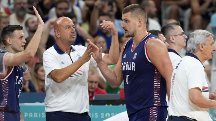 Jul 31, 2024; Villeneuve-d'Ascq, France; Serbia power forward Nikola Jokic (15) celebrates with coaches and teammates after a play in the third quarter against Puerto Rico during the Paris 2024 Olympic Summer Games at Stade Pierre-Mauroy. Mandatory Credit: John David Mercer-USA TODAY Sports