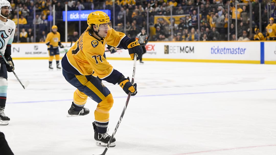 Mar 6, 2025; Nashville, Tennessee, USA;  Nashville Predators right wing Luke Evangelista (77) scores on an empty net shot against the Seattle Kraken during the third period at Bridgestone Arena. Mandatory Credit: Steve Roberts-Imagn Images