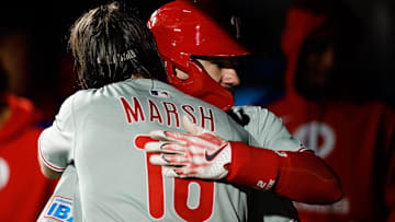  Philadelphia Phillies designated hitter Kyle Schwarber (12) celebrates his solo home run with center fielder Brandon Marsh (16) in the ninth inning against the Colorado Rockies at Coors Field.