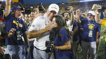 Sep 13, 2025; Morgantown, West Virginia, USA; West Virginia Mountaineers head coach Rich Rodriguez celebrates with his daughter Raquel after defeating the Pittsburgh Panthers at Milan Puskar Stadium. Mandatory Credit: Ben Queen-Imagn Images