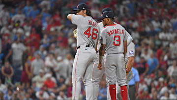 Jul 21, 2025; Philadelphia, Pennsylvania, USA; Boston Red Sox pitcher Jordan Hicks (46) and teammates wait on the mound as officials make the call for catcher's interference during the tenth inning against the Philadelphia Phillies at Citizens Bank Park.