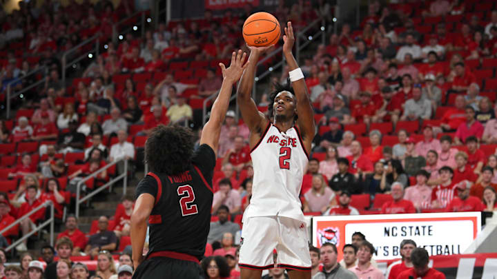 Mar 7, 2026; Raleigh, North Carolina, USA;  NC State Wolfpack guard Paul McNeil Jr. (2) shoots the ball against Stanford Cardinal guard Ebuka Okorie (1) during the first half at Lenovo Center. Mandatory Credit: Zachary Taft-Imagn Images