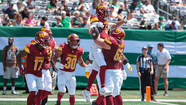 Washington Commanders quarterback Jayden Daniels celebrates touchdown vs. New York Jets with center Tyler Biadasz.