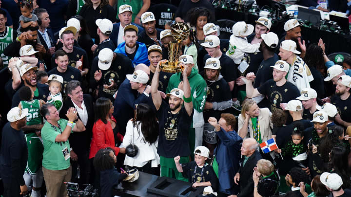 Jun 17, 2024; Boston, Massachusetts, USA; Boston Celtics forward Jayson Tatum (0) celebrates with the trophy on the podium after defeating the Dallas Mavericks in the 2024 NBA Finals at TD Garden. Mandatory Credit: David Butler II-USA TODAY Sports