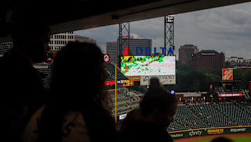 Jul 23, 2024; Atlanta, Georgia, USA; Atlanta Braves fans wait under an overhang during a weather delay before a game against the Cincinnati Reds at Truist Park. 