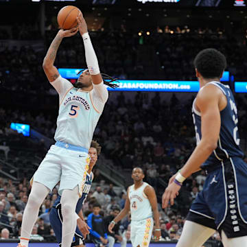 Mar 12, 2025; San Antonio, Texas, USA; San Antonio Spurs guard Stephon Castle (5) shoos over Dallas Mavericks forward Caleb Martin (16) in the first half at Frost Bank Center. Mandatory Credit: Daniel Dunn-Imagn Images