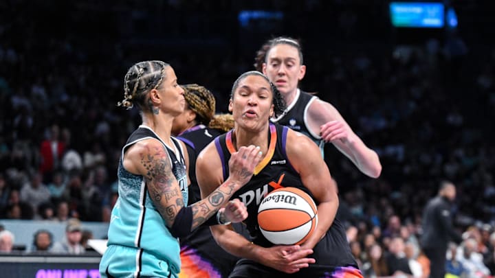 Jun 19, 2025; Brooklyn, New York, USA; Phoenix Mercury forward Alyssa Thomas (25) tries to get past New York Liberty guard Natasha Cloud (9) and forward Breanna Stewart (30) during the second half at Barclays Center. Mandatory Credit: John Jones-Imagn Images