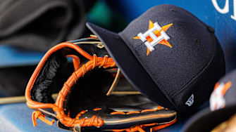 Apr 27, 2025; Kansas City, Missouri, USA; Houston Astros hat and glove in the dugout during the second inning against the Kansas City Royals at Kauffman Stadium. Mandatory Credit: William Purnell-Imagn Images
