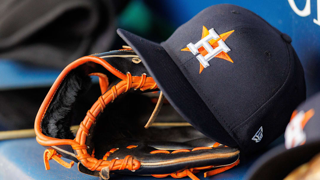 Houston Astros hat and glove in the dugout