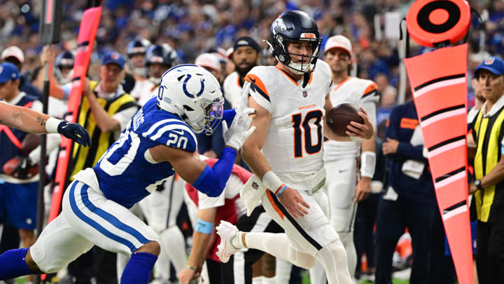 Aug 11, 2024; Indianapolis, Indiana, USA;  Denver Broncos quarterback Bo Nix (10) is pushed out of bounds by Indianapolis Colts safety Nick Cross (20) during the second quarter at Lucas Oil Stadium. 