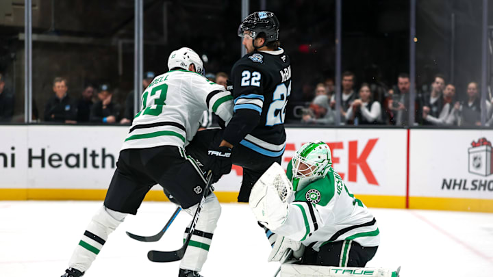 Dec 2, 2024; Salt Lake City, Utah, USA; Dallas Stars goaltender Casey DeSmith (1) catches the puck while defenseman Esa Lindell (23) tries to push Utah Hockey Club center Jack McBain (22) out of the way during the third period at Delta Center. Mandatory Credit: Chris Nicoll-Imagn Images