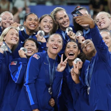 Aug 11, 2024; Paris, France; United States players celebrate with their silver medals on the podium after the women's volleyball gold medal match during the Paris 2024 Olympic Summer Games at South Paris Arena.