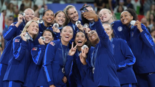 United States players celebrate with their silver medals on the podium after the women's volleyball gold medal match during t